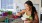 woman eating a bowl of fruit in her kitchen