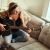 woman plays guitar on a couch