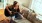 woman plays guitar on a couch