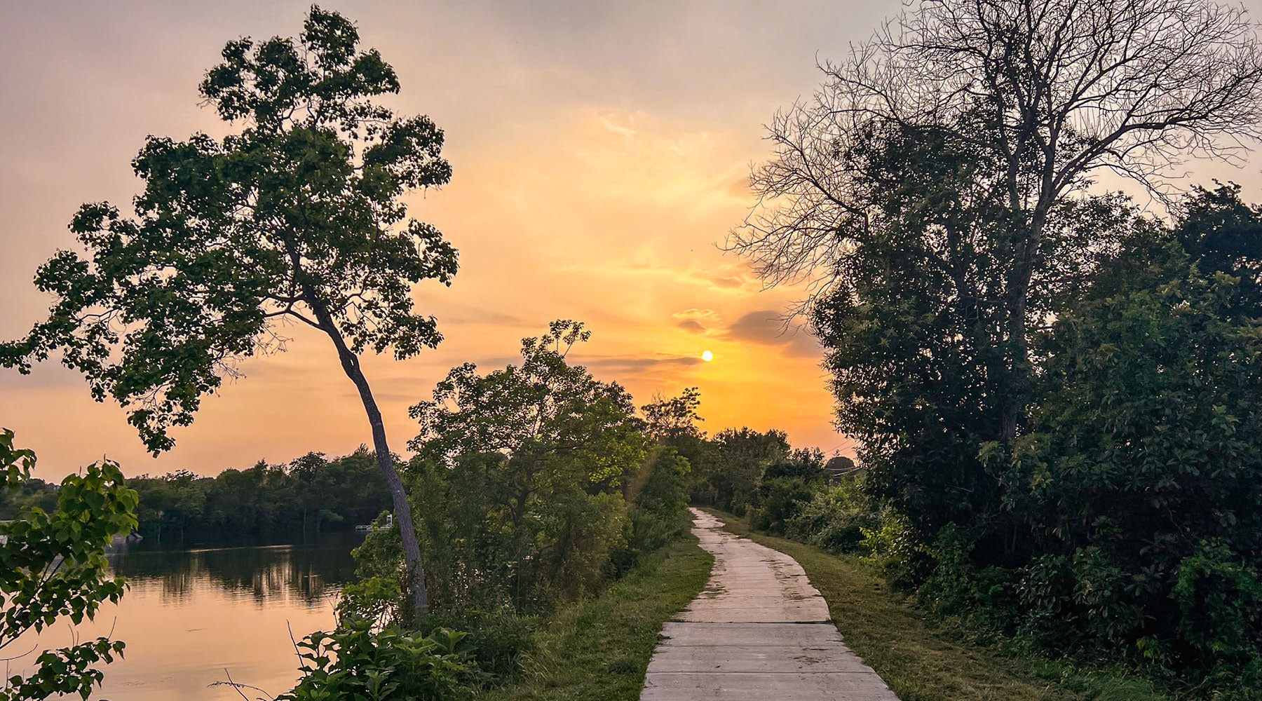 A beautiful community at the heart of all your passions park trail along a river