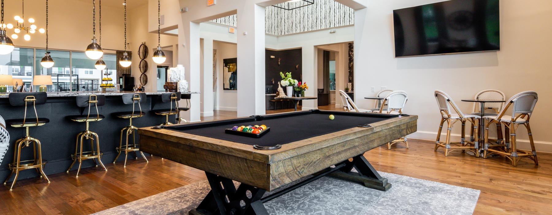 a room with a pool table and chairs
